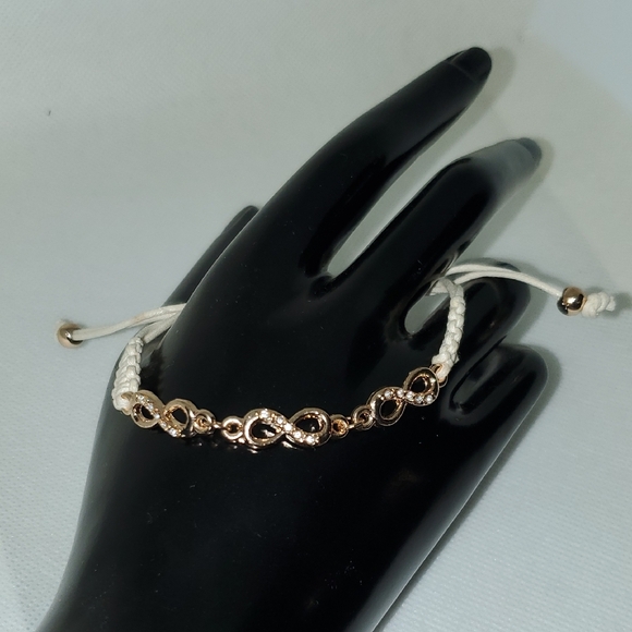 Gold and White Infinity Bracelet with Intricate Design - Picture 1 of 8